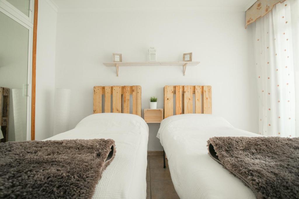 twee bedden in een kamer met witte muren bij NJOYLIFE APARTMENT in Adeje