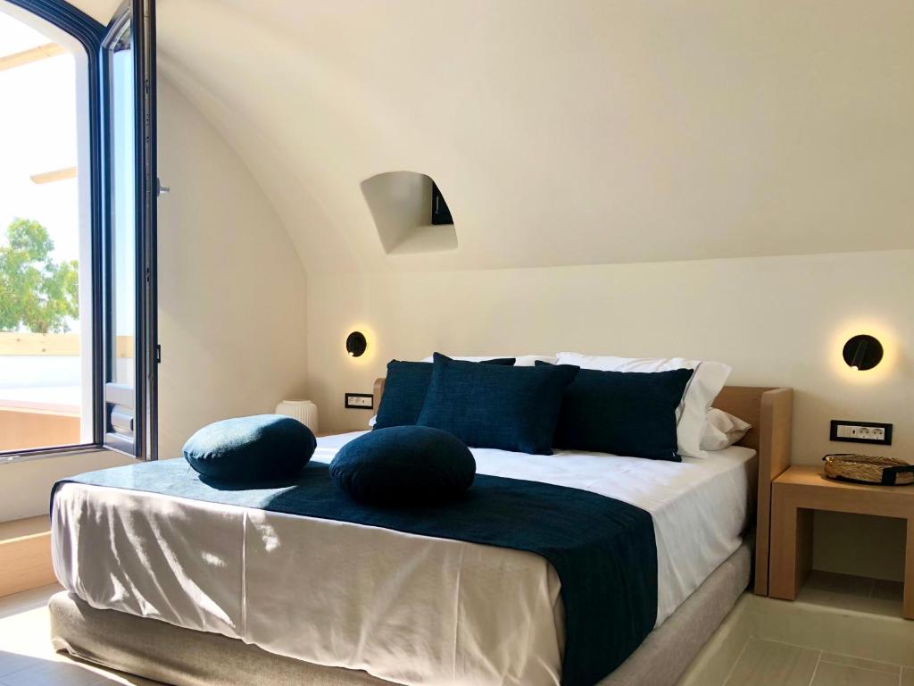 a bedroom with a bed with two pillows on it at Candele Suites in Fira