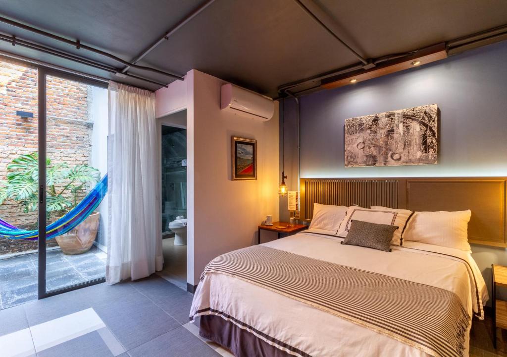 a bedroom with a bed and a large window at The Yellow by DOT Boutique in Guadalajara