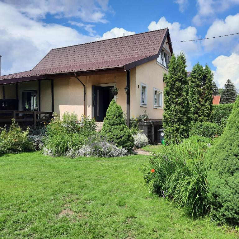 a house with a yard in front of it at Dom w (Między) lesie in Zwierzewo