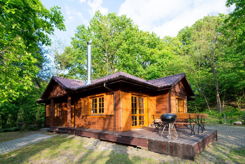 a log cabin with a grill on a deck at Domek na Stoku in Kazimierz Dolny
