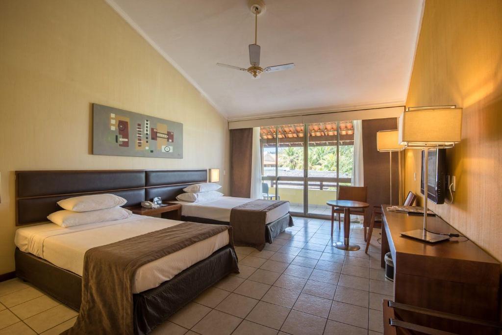 カボ・デ・サント・アゴスチーニョにあるVila Galé Eco Resort do Cabo - All Inclusiveのベッド、デスク、テレビが備わるホテルルームです。