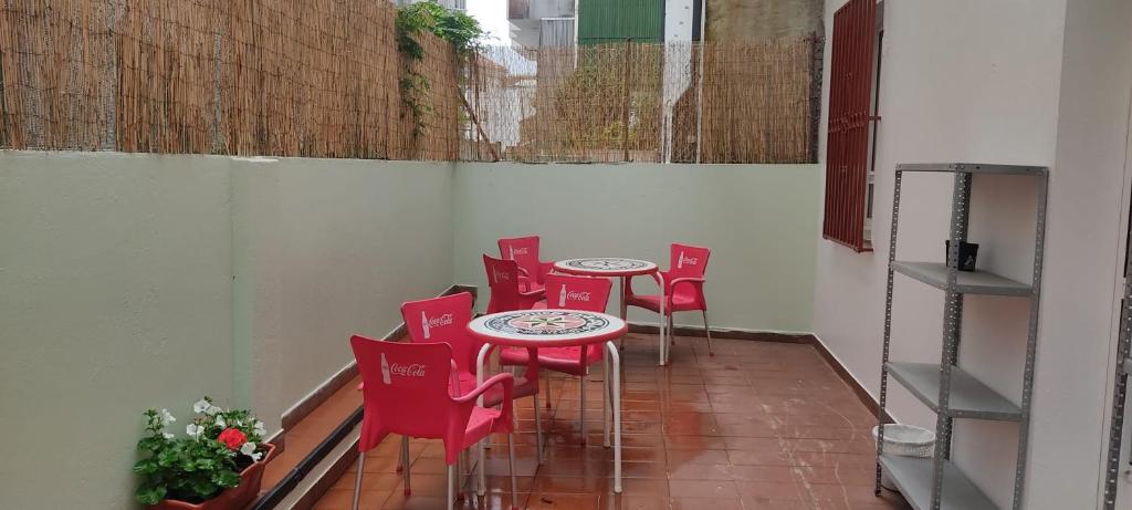 Albergue Santos في سانتياغو دي كومبوستيلا: صف من الكراسي الحمراء والطاولات في الغرفة