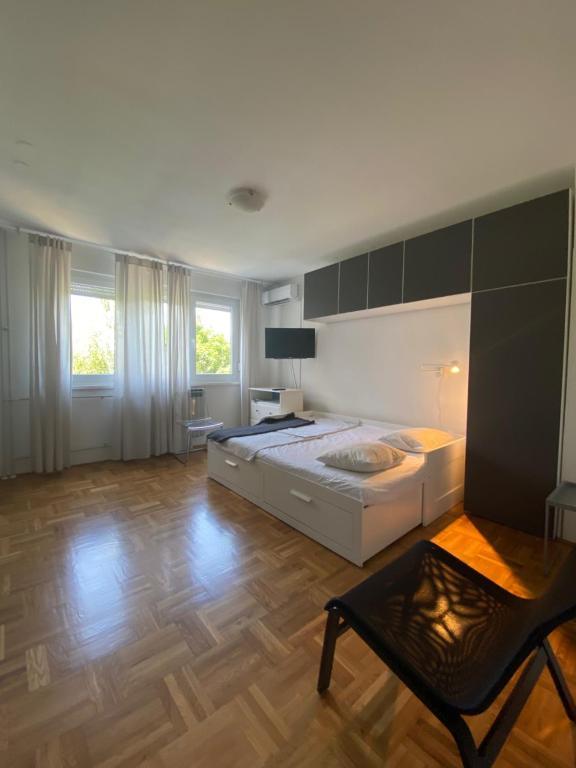 een grote slaapkamer met een groot bed en een houten vloer bij West vibes apartment in Zagreb