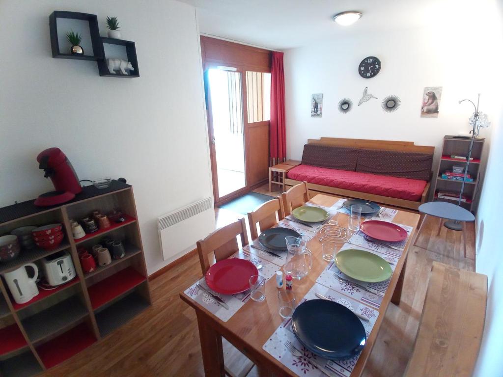 una sala de estar con una mesa con platos. en Au bon endroit N2 - Appartement 2 pièces 7 personnes - proche pistes - Belle vue, en Orcières