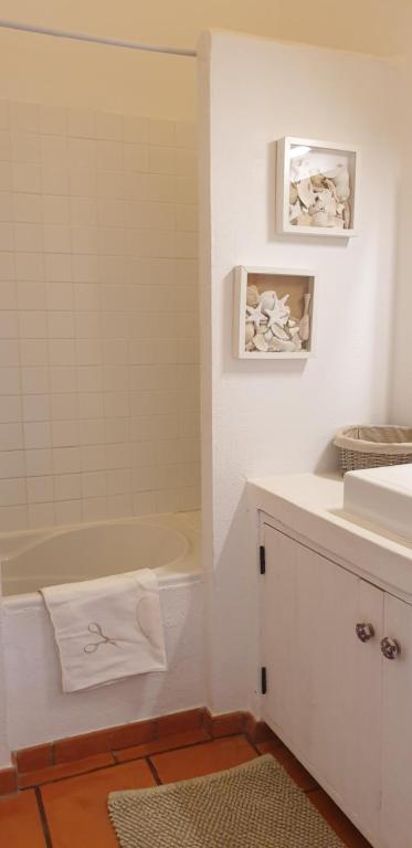 a white bathroom with a tub and a sink at Comporta House in Comporta