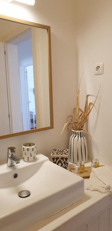 a bathroom with a white sink and a mirror at Comporta House in Comporta