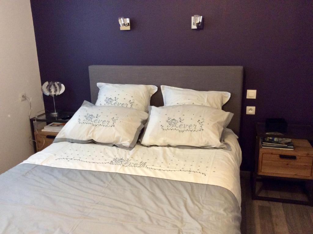 Schlafzimmer mit einem Bett mit weißer Bettwäsche und Kissen in der Unterkunft Chambre tout confort du Tilleul in Bosc-Bénard-Commin