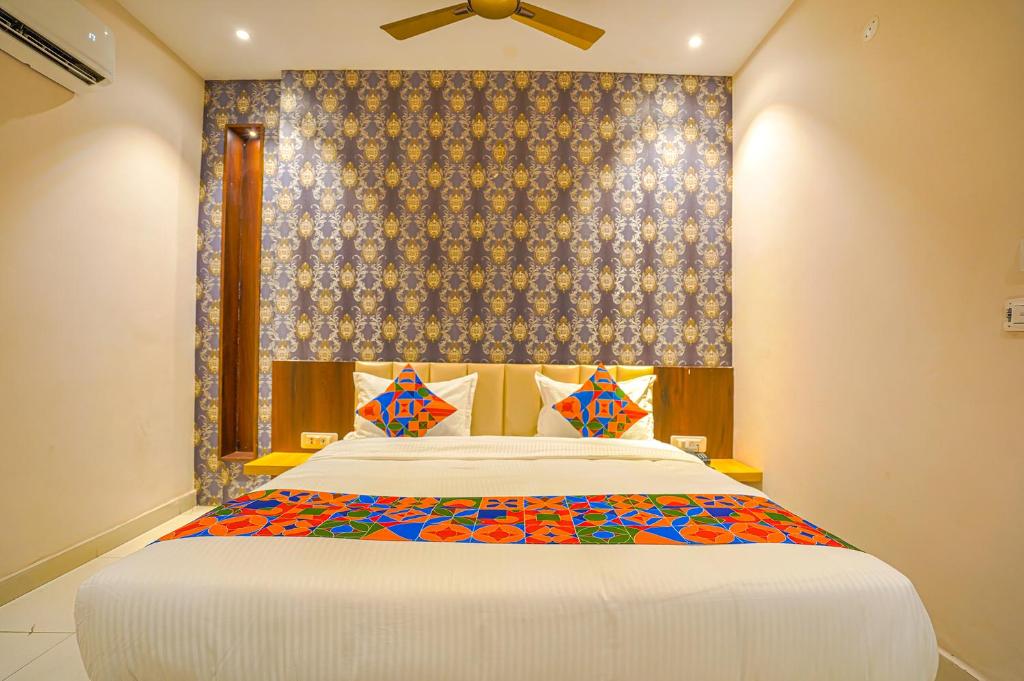 um quarto com uma cama grande e uma parede azul em FabHotel Prime Empire em Amritsar