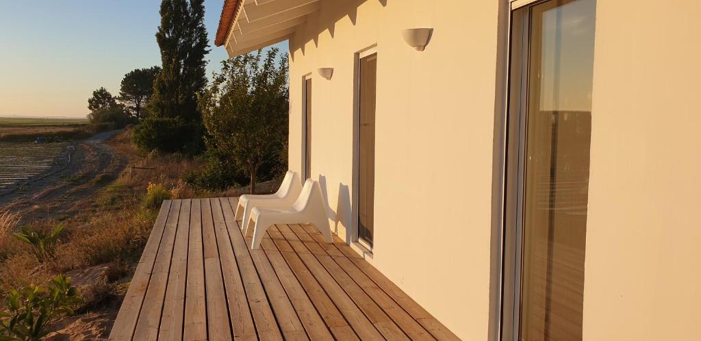 a wooden walkway next to a building with a window at Comporta House in Comporta