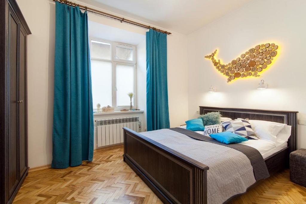 リヴィウにあるApartment on Krakivska streetのベッドルーム1室(青いカーテン付きのベッド1台付)