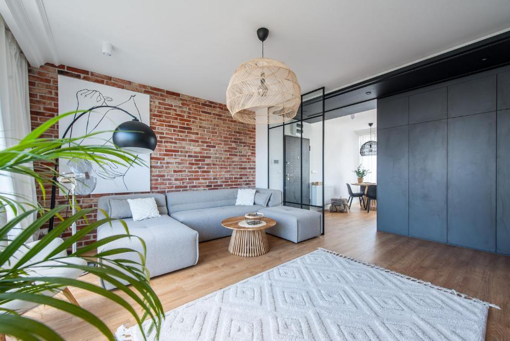 salon z niebieską kanapą i ceglaną ścianą w obiekcie Luxury Port View - BillBerry Apartments w mieście Gdynia
