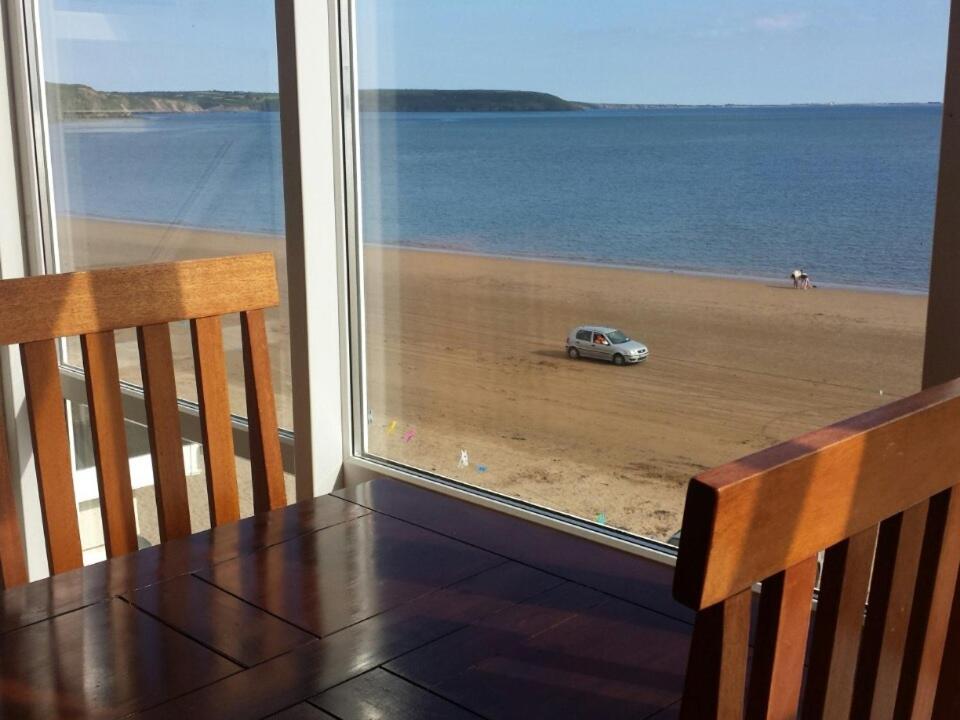 a table with a view of the beach and a car at Seashells B&B in Duncannon
