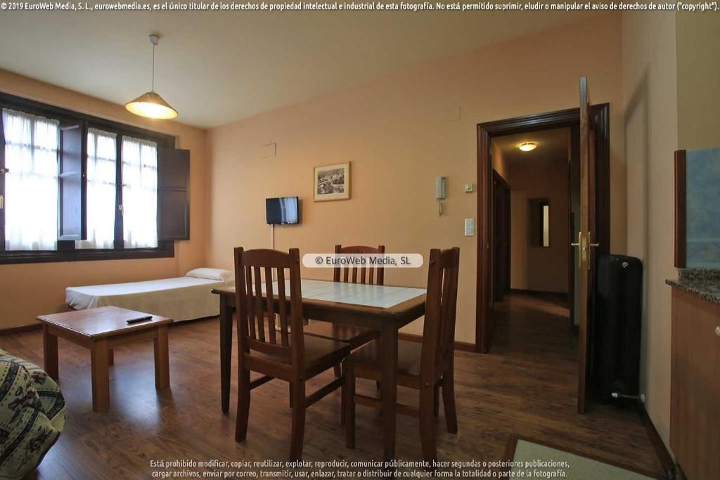 sala de estar con mesa, sillas y cama en Apartamento 2 casa graciano, en Cangas de Onís