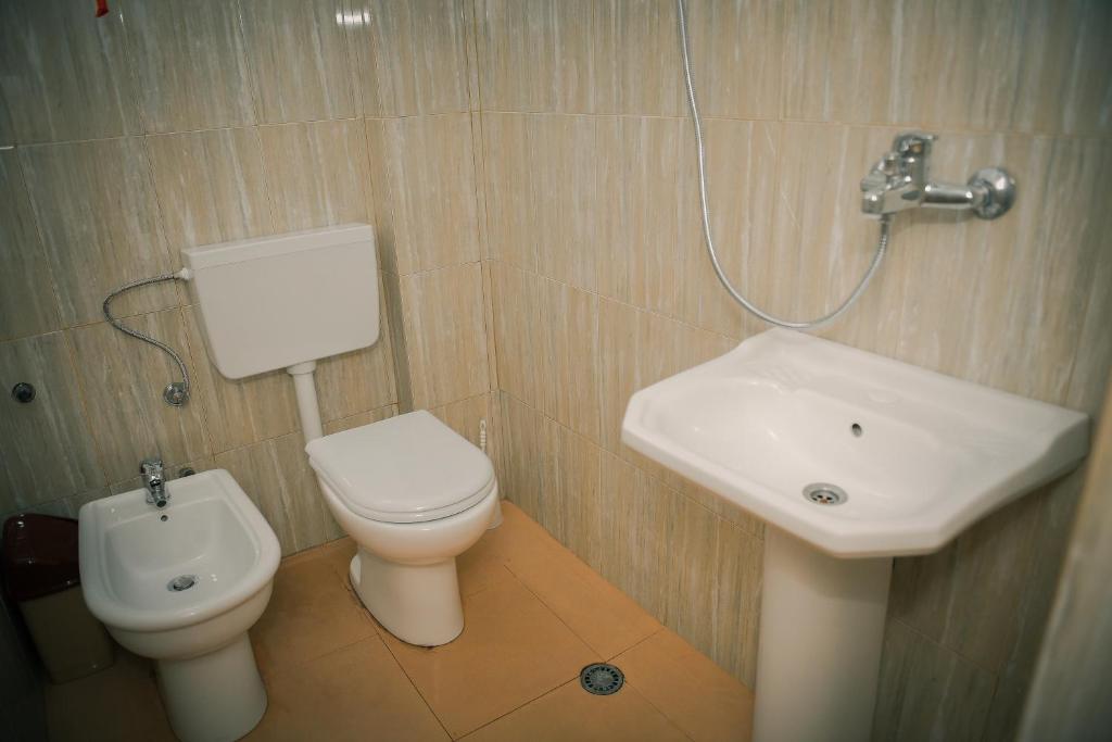 a bathroom with a toilet and a sink at Central Hostel in Shkodër