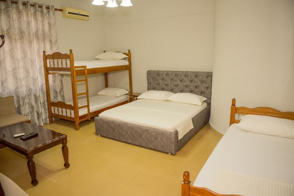 Habitación con 2 camas y 1 litera en Hostel Central Shkoder, en Shkodër