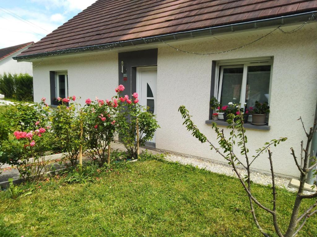 een wit huis met roze bloemen in een tuin bij Séjour chaleureux chambre chez l habitant in Torpes