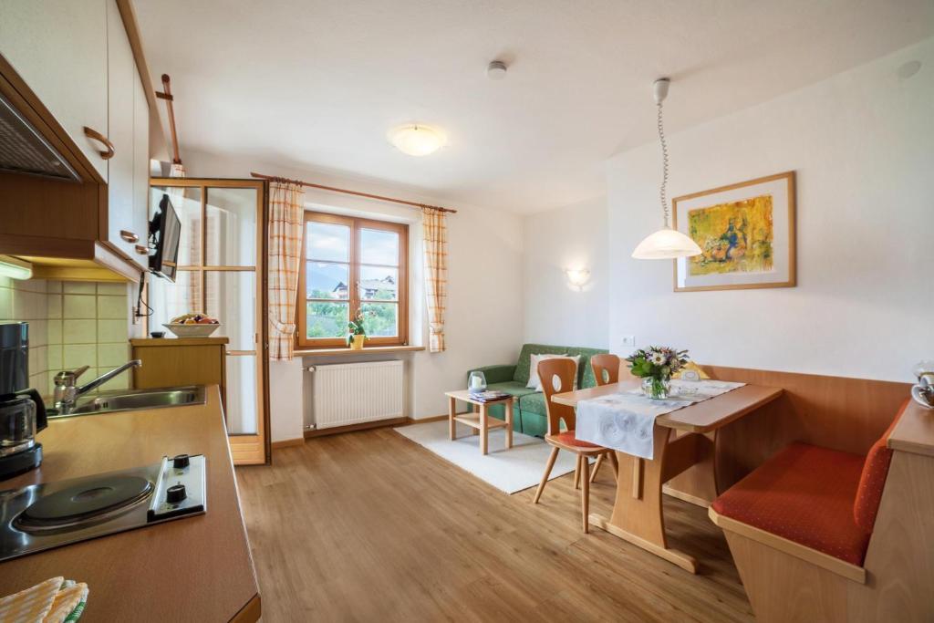 een keuken en een woonkamer met een tafel en stoelen bij Hahnenkamm Rainegg in Schenna