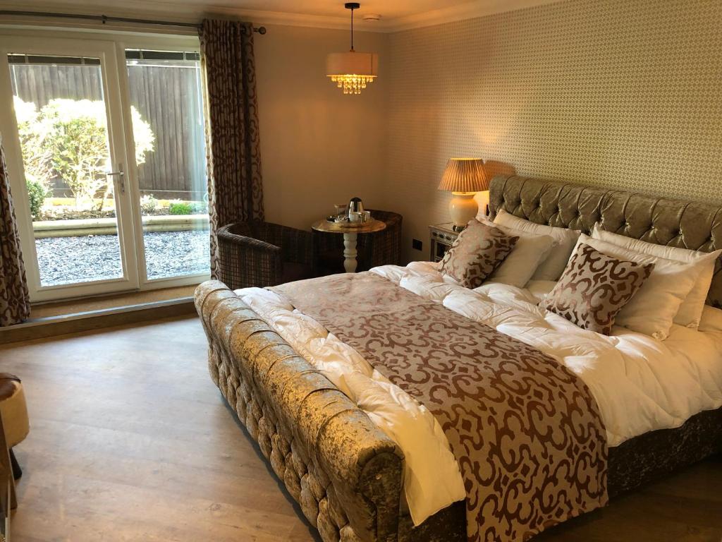 a bedroom with a large bed in a room with a window at Willow Lodge Hambleton in Poulton le Fylde