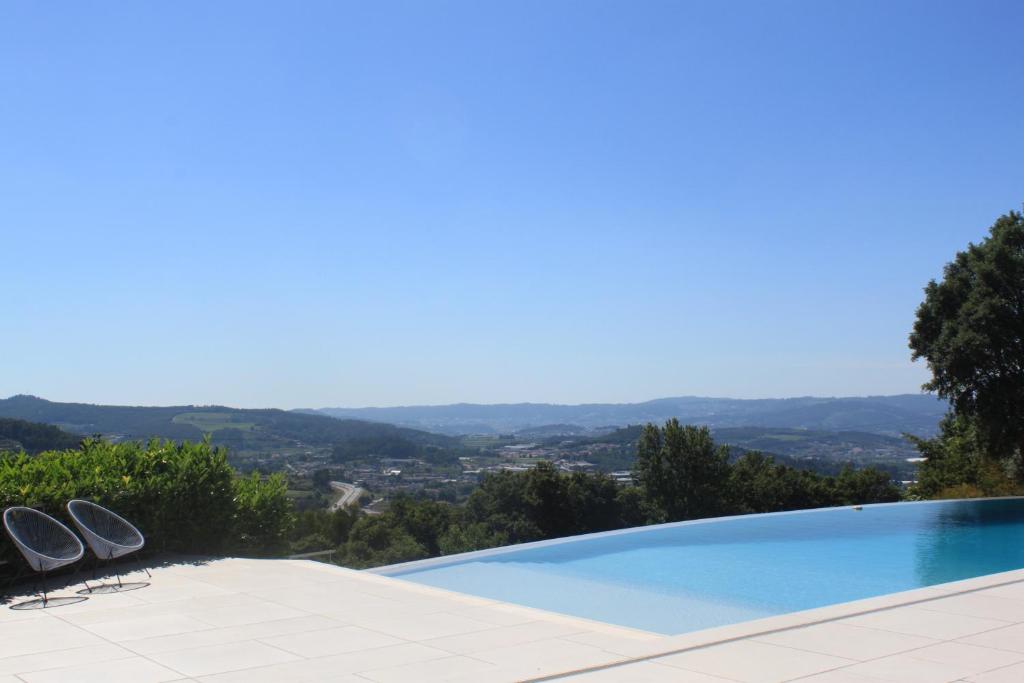 a swimming pool with a view of the mountains at Quinta Milhão - Casa do Pomar in Guimarães