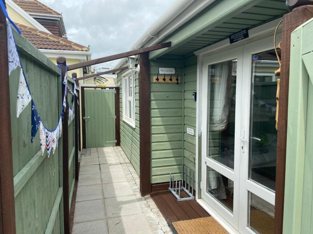 a walkway leading into a green house with a door at Hideaway at Botany Bay in Broadstairs