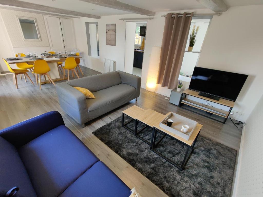 un salon avec un canapé et une table dans l'établissement Homefleur - Grand appartement avec jardin 4-6 personnes, à Honfleur