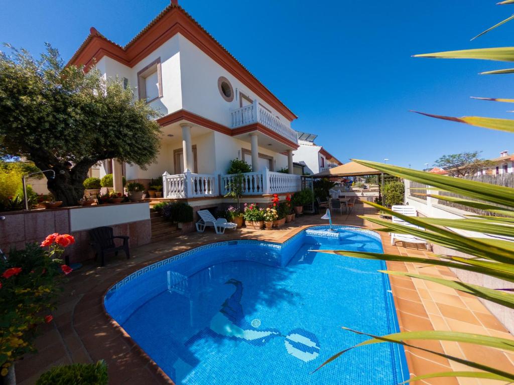 a villa with a swimming pool in front of a house at Alojamiento El Olivo in Ronda