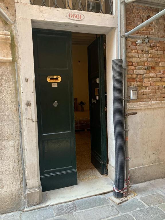two green doors in a building with a brick wall at Melusina Homes in Venice