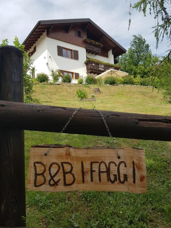 a sign hanging on a fence in front of a house at B&B I FAGGI in Lavarone