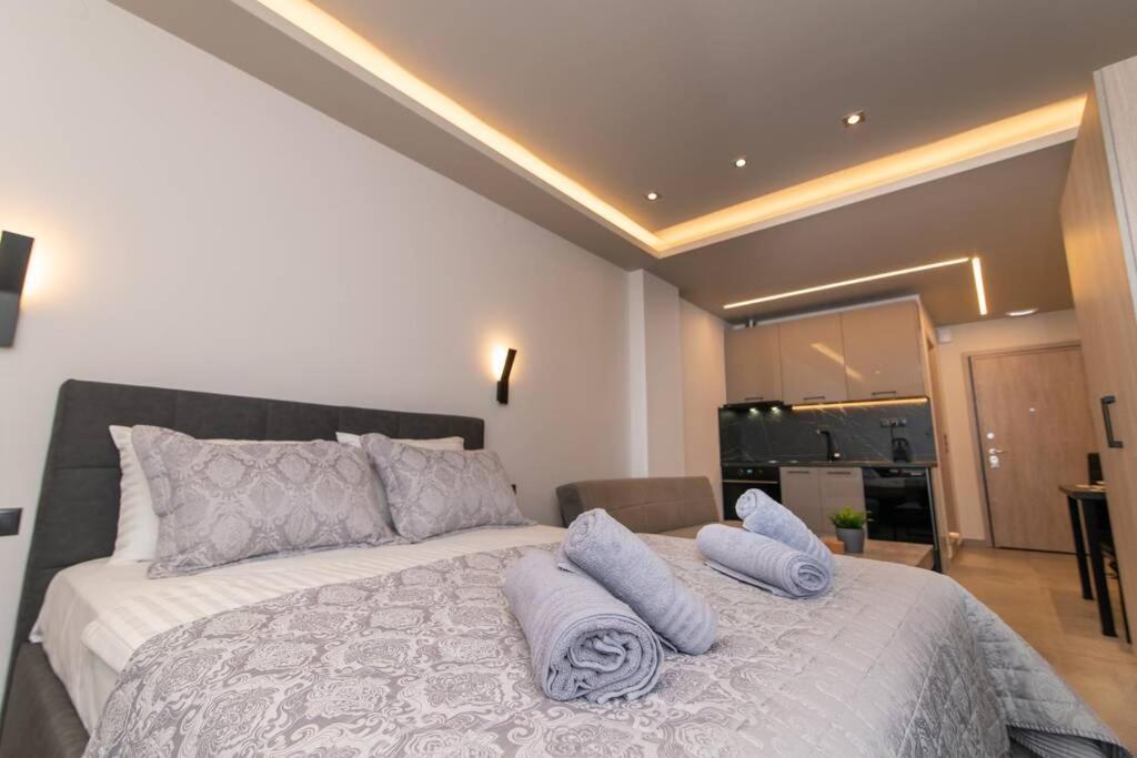 een slaapkamer met een groot bed met kussens erop bij Kastalia Living Thessaloniki in Thessaloniki