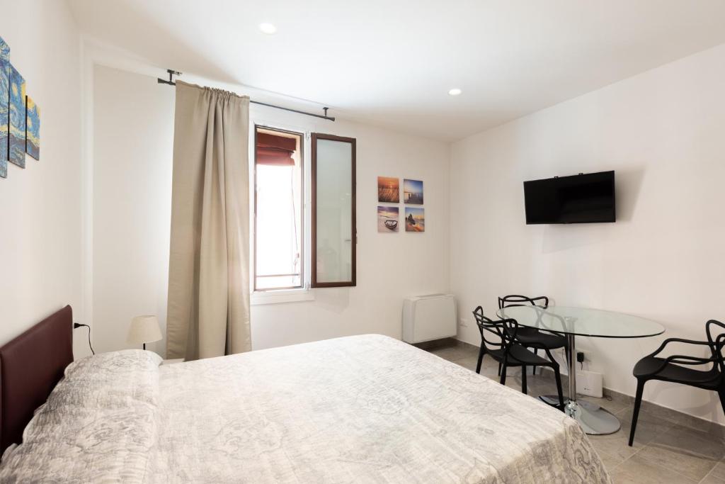 a white bedroom with a bed and a table at Marsala, Bologna by Short Holidays in Bologna