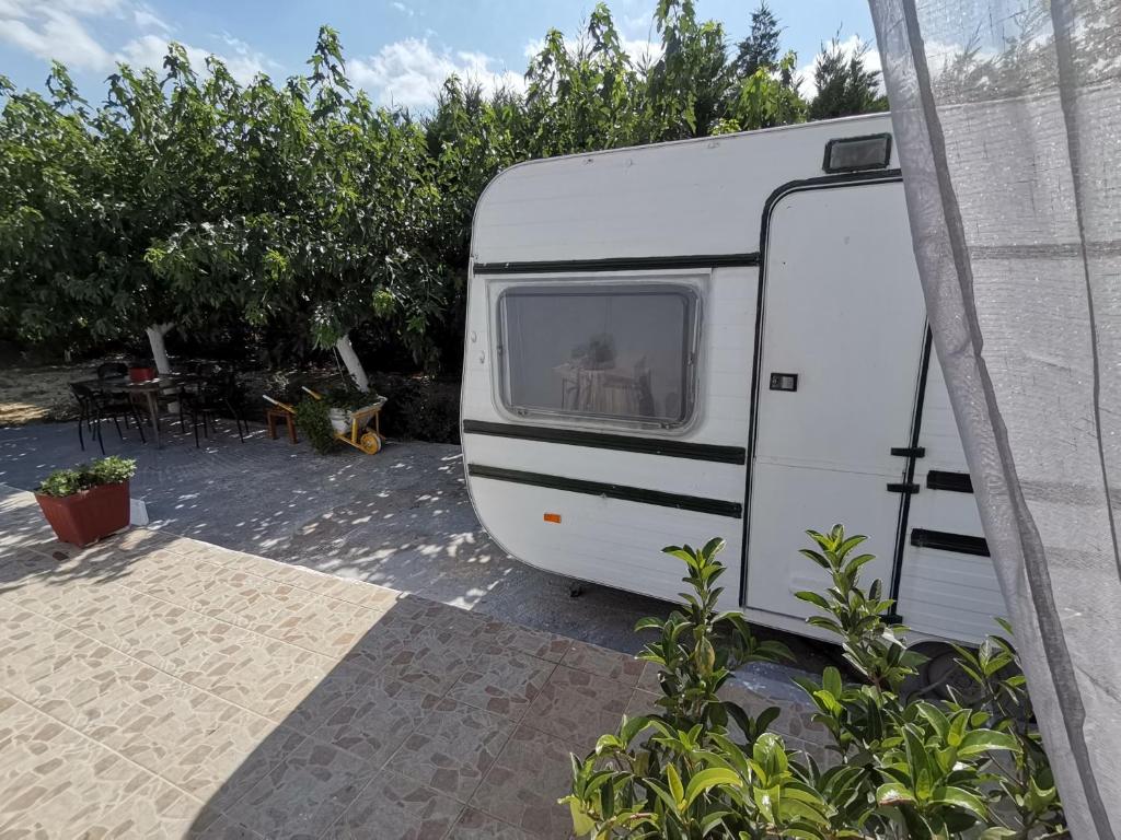een witte trailer geparkeerd naast een gebouw bij Green Garden Caravan in Zakynthos