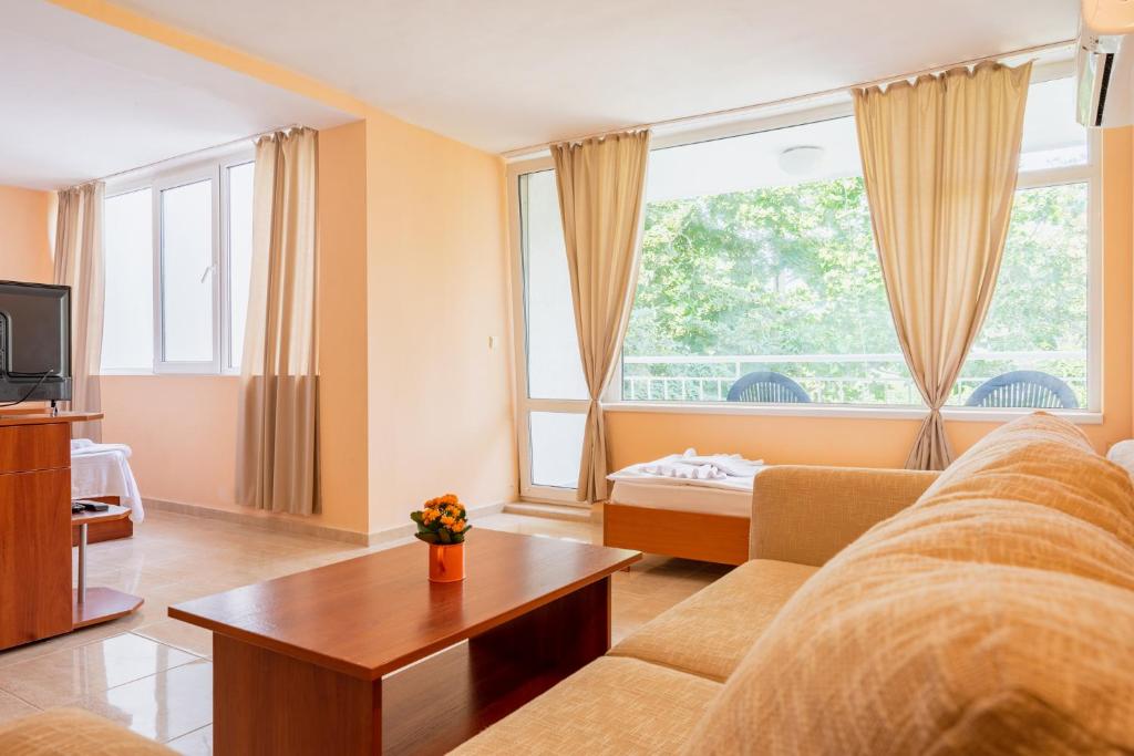 - un salon avec un canapé et une grande fenêtre dans l'établissement Хотел Ескана, à Shkorpilovtsi