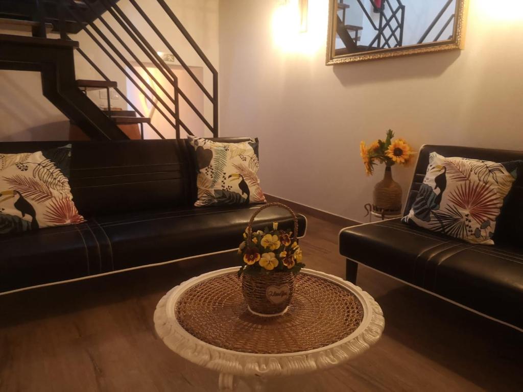 een woonkamer met een bank en een tafel met een mand met bloemen bij Casa D'Aldeia in Aldeia da Mata
