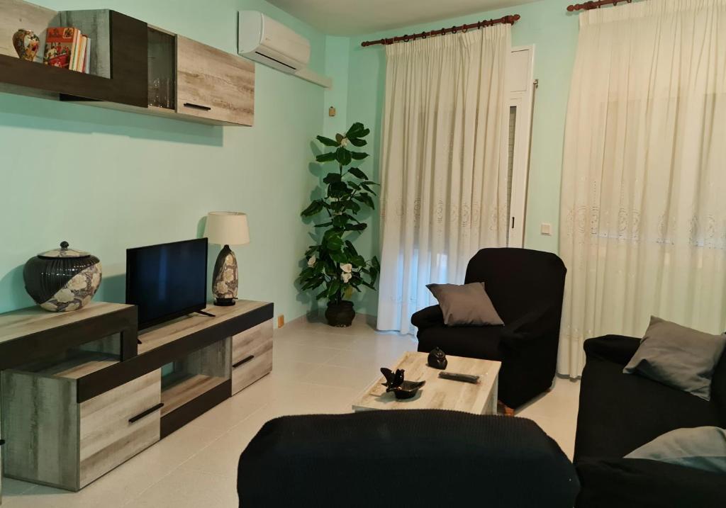 sala de estar con 2 sillas y TV en Casa Mirador, en Alcanar