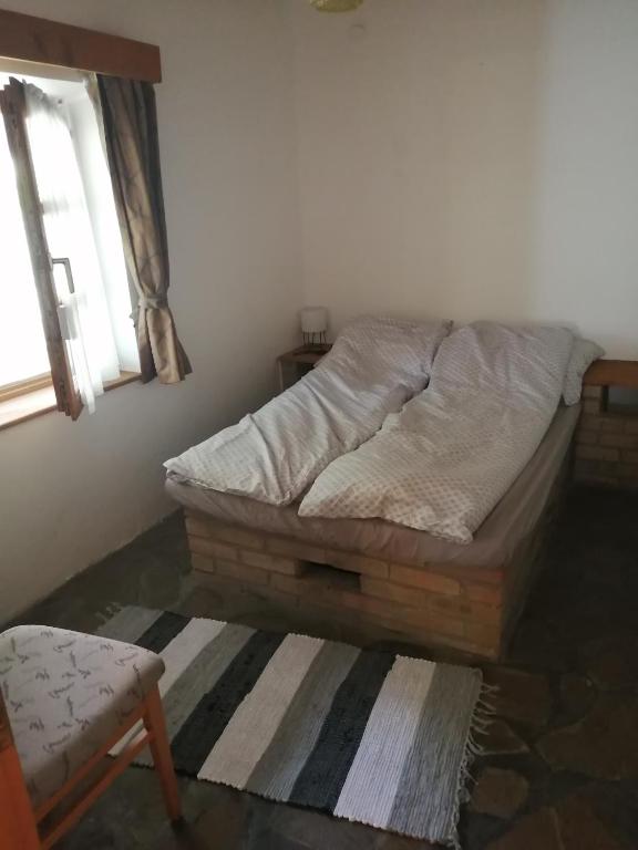 łóżko stojące w pokoju z oknem w obiekcie Lisztes Apartman (medencés, nádfedeles, Zamárdi) w Zamárdi