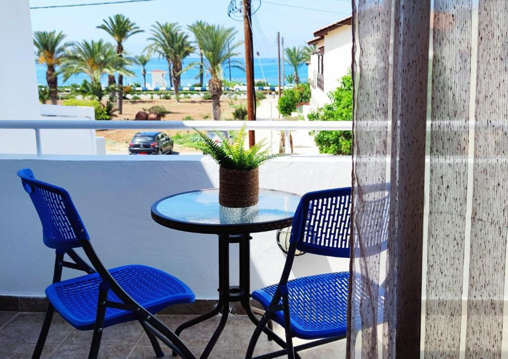 een tafel en stoelen op een balkon met uitzicht op het strand bij Mediterranean Seaside Authentic Beach House in Polis Chrysochous
