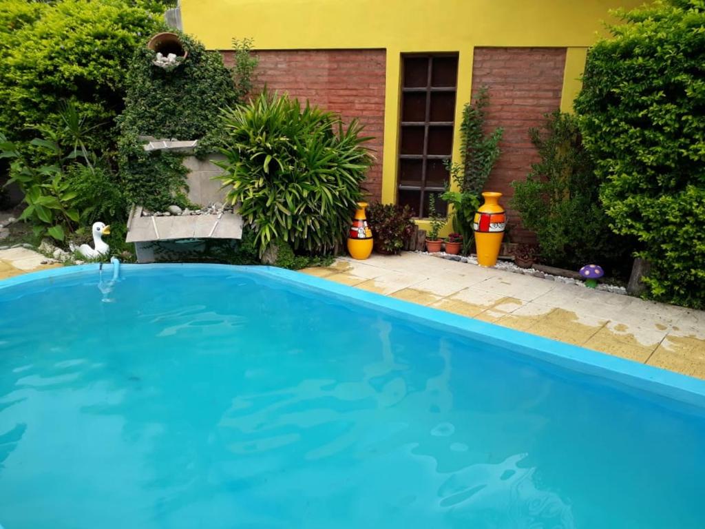 uma grande piscina azul em frente a uma casa em Las Casuarinas em Paraná