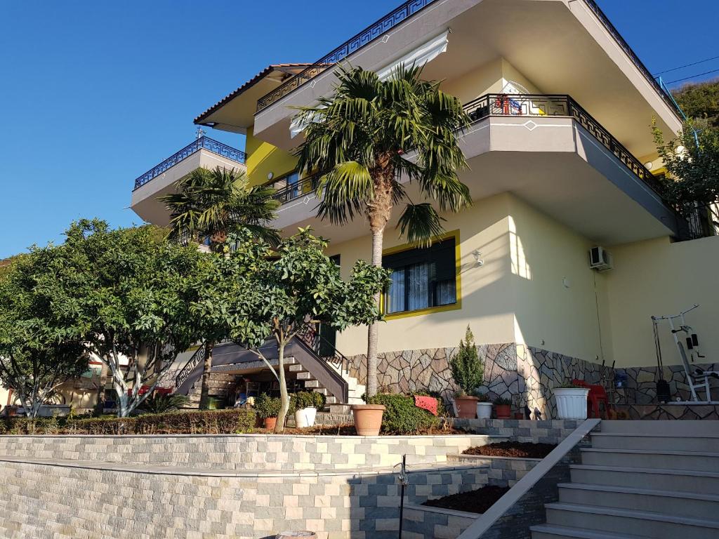 a building with palm trees in front of it at Villa Meminaj Vlore Sea view and Garden Vlore in Vlorë