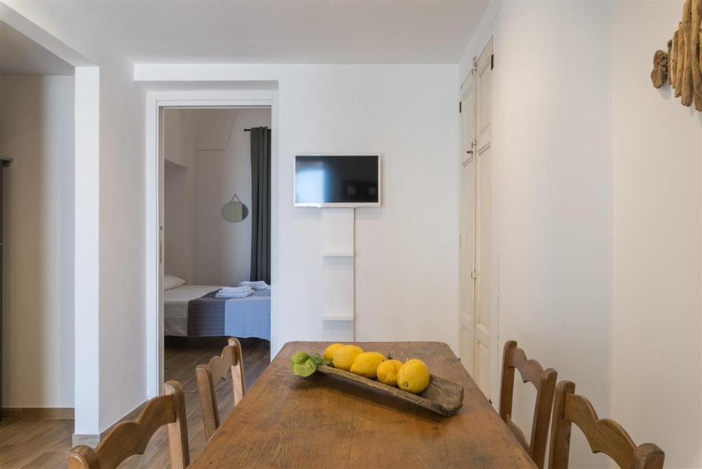 a dining room with a wooden table with fruit on it at Casetta Mare in Villanova di Ostuni