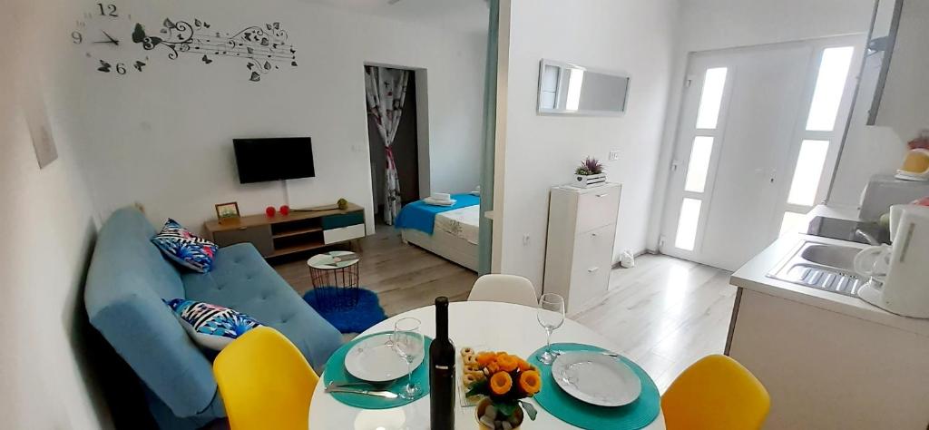 sala de estar con mesa y algunas sillas en Lennida Studio Apartman, en Kavran