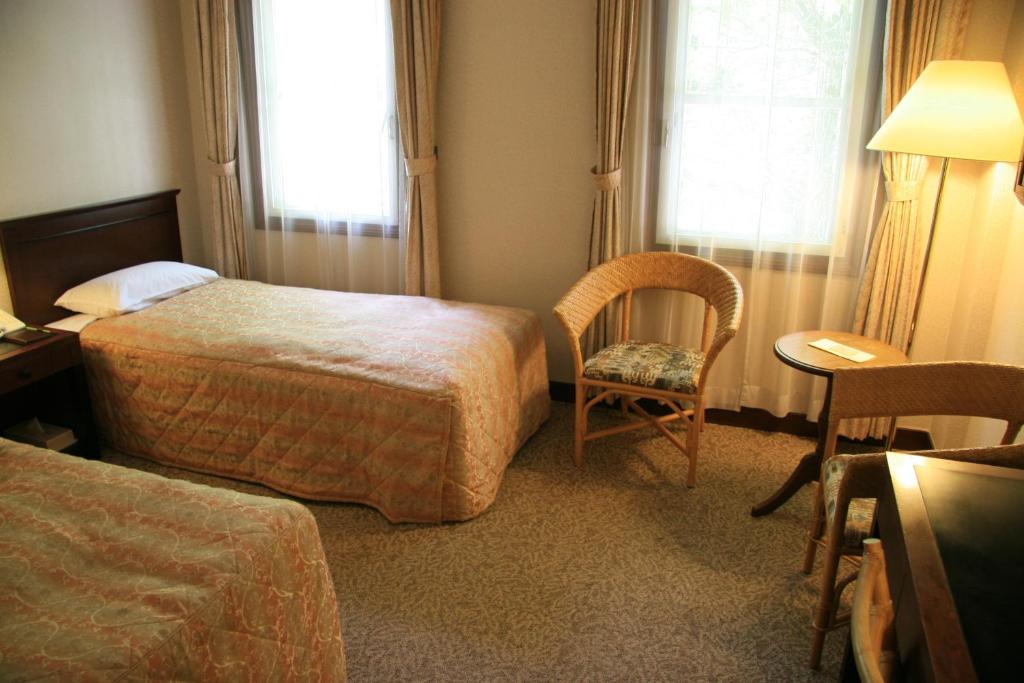 Postel nebo postele na pokoji v ubytování Kyu Karuizawa Hotel Otowa No Mori