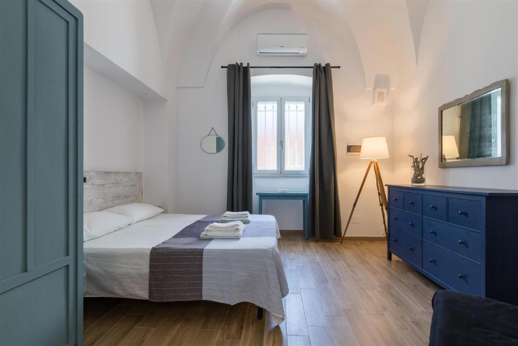 a bedroom with a bed and a blue dresser at Casetta Mare in Villanova di Ostuni