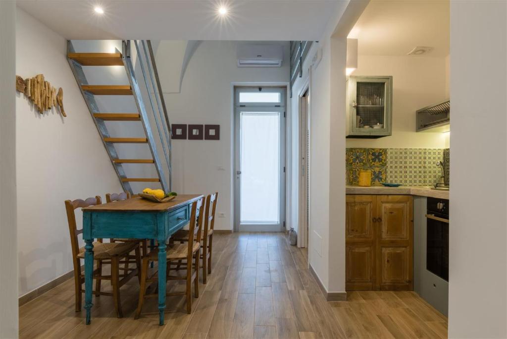 a kitchen and dining room with a table and a staircase at Casetta Mare in Villanova di Ostuni