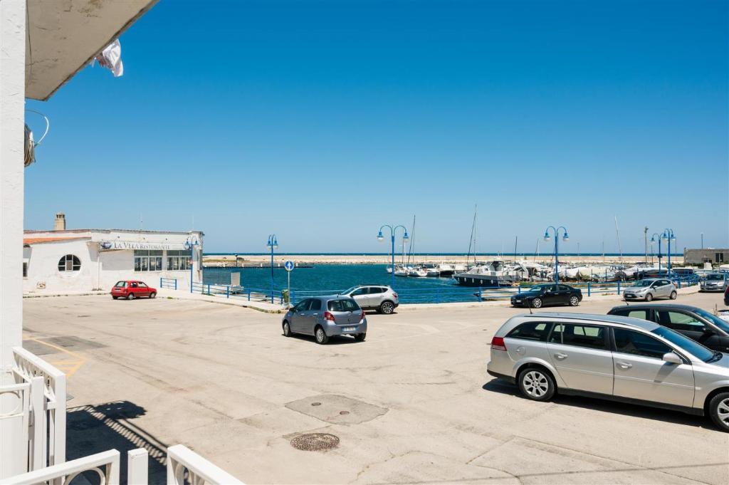 a parking lot with cars parked next to the water at Casetta Mare in Villanova di Ostuni