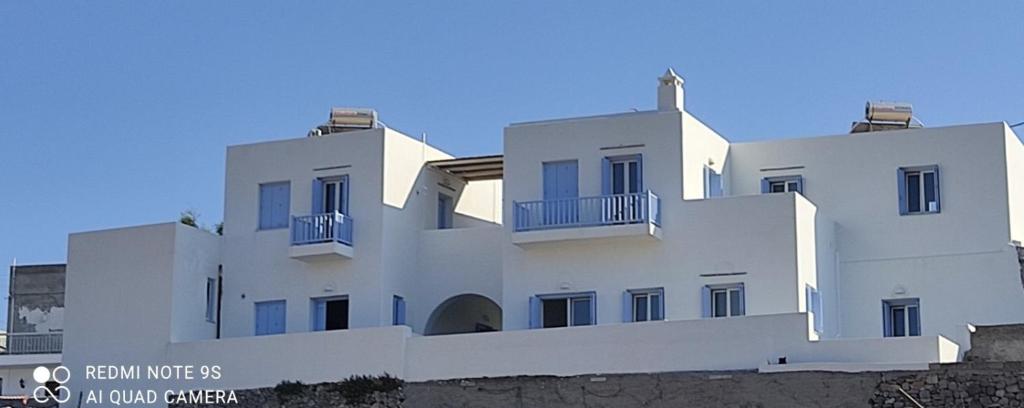 a white building with balconies on the side of it at Stilvi Milos in Plaka Milou