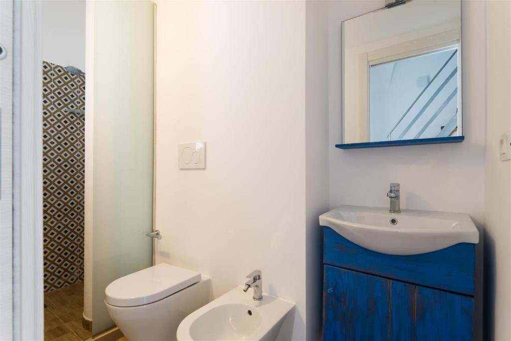 a bathroom with a sink and a toilet and a mirror at Casetta Mare in Villanova di Ostuni