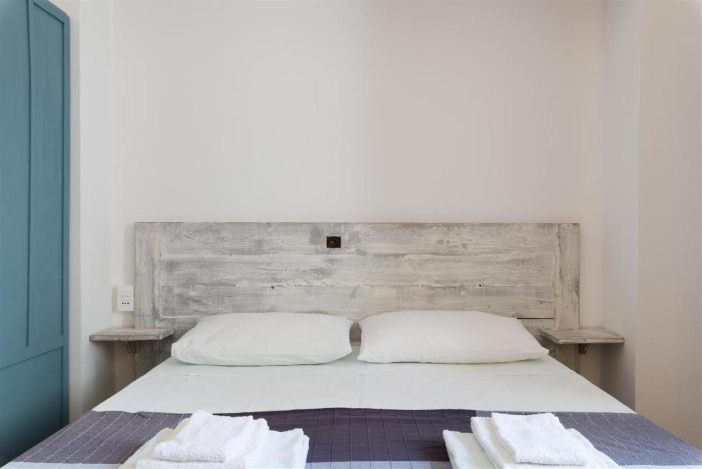 a bed with two white pillows and a wooden headboard at Casetta Mare in Villanova di Ostuni