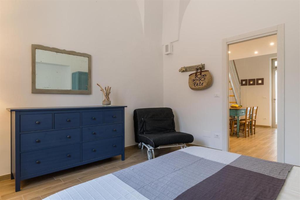 a bedroom with a blue dresser and a mirror and a chair at Casetta Mare in Villanova di Ostuni