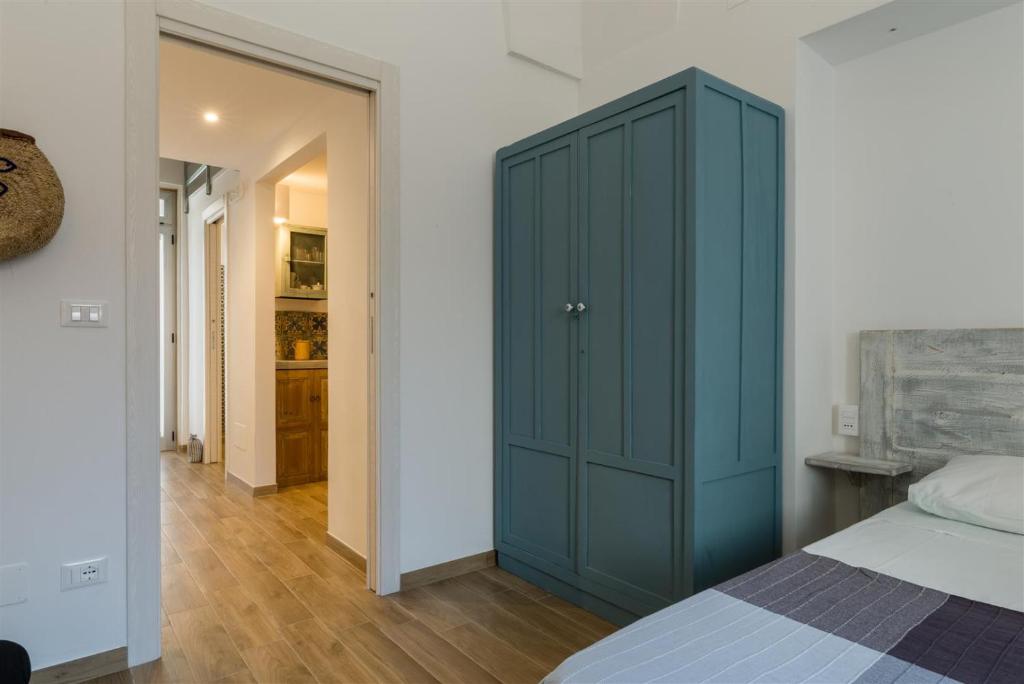 a bedroom with a blue cabinet next to a bed at Casetta Mare in Villanova di Ostuni